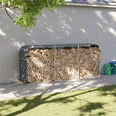 Anthracite galvanized steel log holder with firewood stacked inside, against a white wall.